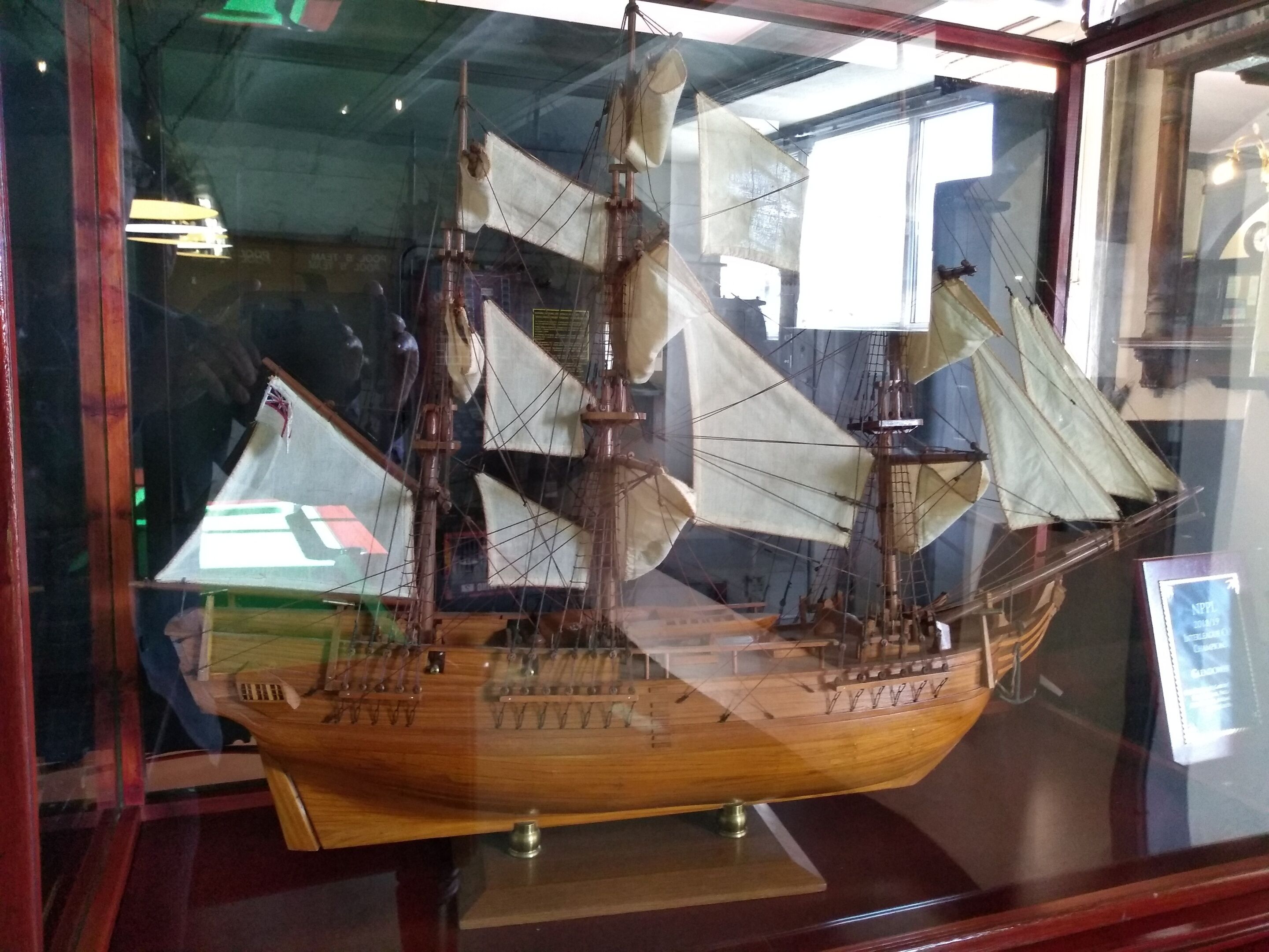 A model ship displayed in a glass case.