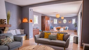 Uma sala de estar com sofá, mesa de centro e um espaço de jantar com cadeiras e mesa.
