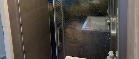 Chuveiro, secador de cabelo, sabonete, papel higiênico