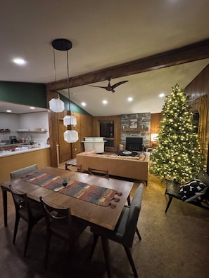 Ein gemütlicher Essbereich mit Holztisch, Stühlen und einem Weihnachtsbaum.