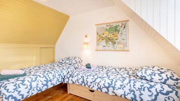 Une chambre avec deux lits, une carte accrochée au mur et un plafond en bois.