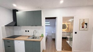 Una cocina funcional con lavavajillas integrado, un fregadero y una estufa.
