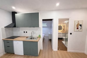 A compact kitchen with a built-in dishwasher, a sink, and a stove. - Sejour familial spacieux a Aubervilliers pour 4 (Aubervilliers)