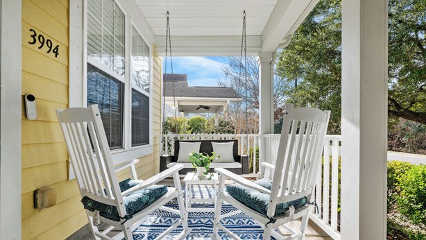 A porch with white rocking chairs and a patterned rug. - Holy City Hideaway | Minutes from Everything (North Charleston)