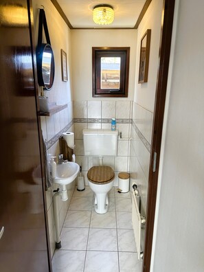 A compact bathroom with a toilet, bidet, and sink.