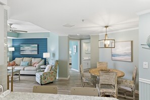 A living room with a sofa, chairs, a dining table, and a ceiling fan. - 10th Floor Westwinds Updated 2BR/2BA Condo at Sandestin (Miramar Beach)