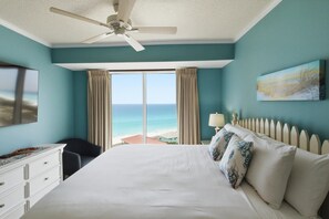 A bedroom with a bed, a ceiling fan, a TV, a desk, a chair, a window with curtains, and a painting. - 10th Floor Westwinds Updated 2BR/2BA Condo at Sandestin (Miramar Beach)