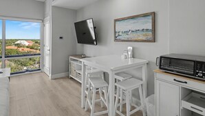 A modern kitchen with a white countertop, a microwave, and a painting on the wall. - Studio condo on 7th Floor at Luau in Sandestin Golf & Beach Resort (Miramar Beach)