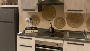 Una cucina moderna con forno integrato, cappa aspirante nera e angolo caffè.