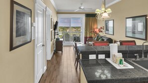 A modern kitchen with a dining area, a ceiling fan, and a view of the outdoors. - Stylish 1BR condo in The Grand at Sandestin Golf & Beach Resort! (Miramar Beach)