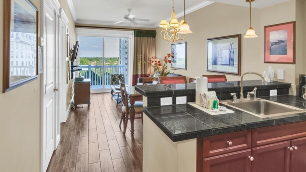 A modern kitchen with a large island, a dining area with a view, and a balcony with a cityscape view. - Stylish 1BR condo in The Grand at Sandestin Golf & Beach Resort! (Miramar Beach)