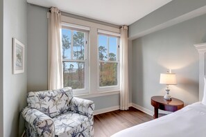 A hotel room with a bed, a chair, a nightstand with a lamp, and a window with curtains. - 1BR Bahia Condo at Sandestin Golf & Beach Resort (Miramar Beach)