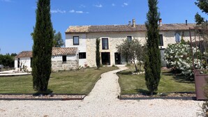 A stone building with a tiled roof, a gravel driveway, and a well-maintained lawn. - Domaine Mas Lafleur - Mas Provençal for 12 people - Swimming pool & large garden (Châteaurenard)