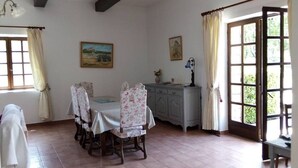 Un comedor con una mesa redonda, sillas y un aparador.