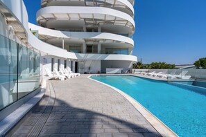 Una piscina al aire libre de temporada, sillones reclinables de piscina