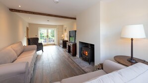 Ein Wohnzimmer mit Kamin, Sofas und einer Lampe.