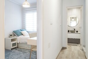 Ein modernes Schlafzimmer mit Bett, Nachttisch und einem Fenster mit Jalousien.