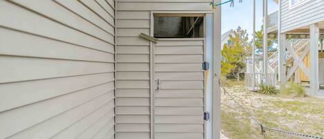 A beige exterior wall with a small door and a wooden deck area.