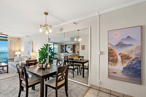 Een moderne hotelkamer met een zithoek, een grote spiegel en een schilderij van een waterval.