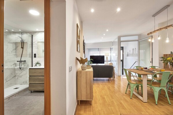 A modern kitchen with a wooden countertop, green chairs, and a dining table. - BBarcelona Guinardó Flat (Barcelona)