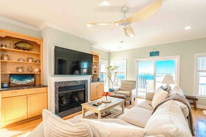 A living room with a fireplace, television, and seating area. - Soundside Sunsets - Gorgeous Home with Gorgeous Sound Views; 4 BR/4.5 Baths (Surf City)