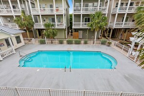 A rectangular pool surrounded by a white fence, with a multi-story building in the background. - Soundside Sunsets - Gorgeous Home with Gorgeous Sound Views; 4 BR/4.5 Baths (Surf City)