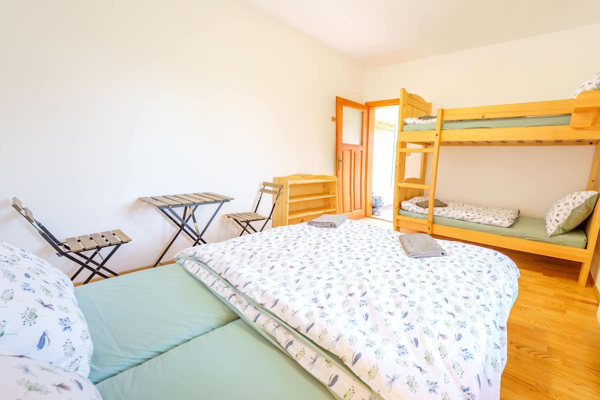 A bedroom with a bunk bed, a desk, and a chair.