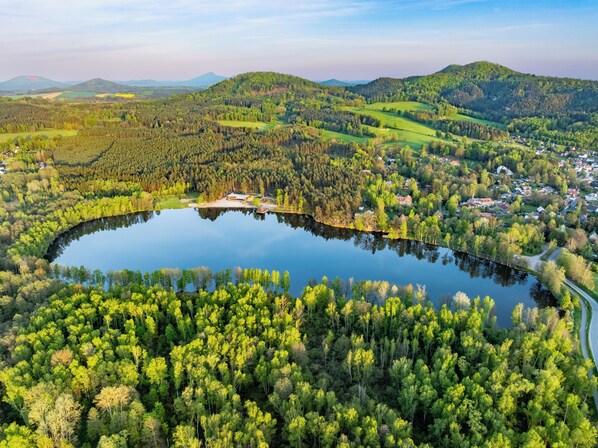 A lake surrounded by dense forest and a small village.