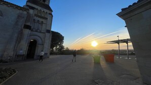 A historic building with a clock tower, a paved walkway, and a sunset in the background. - Near ARKEA ARENA for this room with an incredible view (Bouliac)