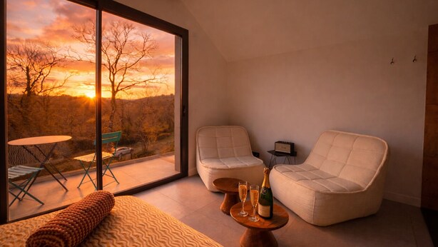 A modern room with a large window, two cushioned chairs, a small table with a bottle and glasses, and a view of a sunset. - Near ARKEA ARENA for this room with an incredible view (Bouliac)
