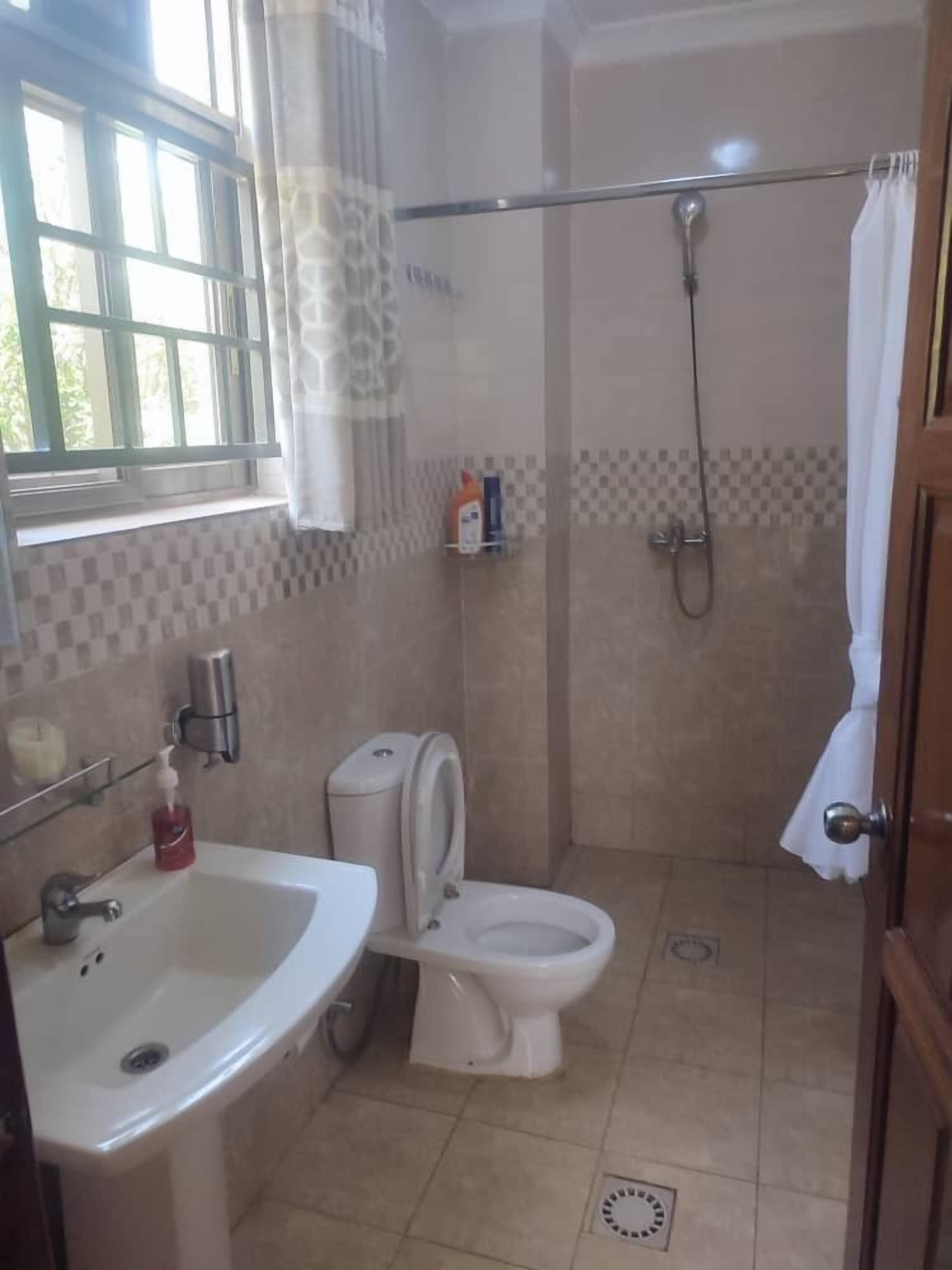 A bathroom with a sink, toilet, and shower.