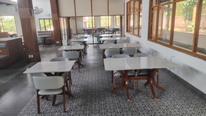 Un'aula con file di banchi e sedie, ampie finestre e un pavimento decorato.