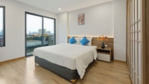 A modern bedroom with a large bed, a nightstand, a vase with flowers, and a city view through a sliding door. - Residence Suite (Hanoi)