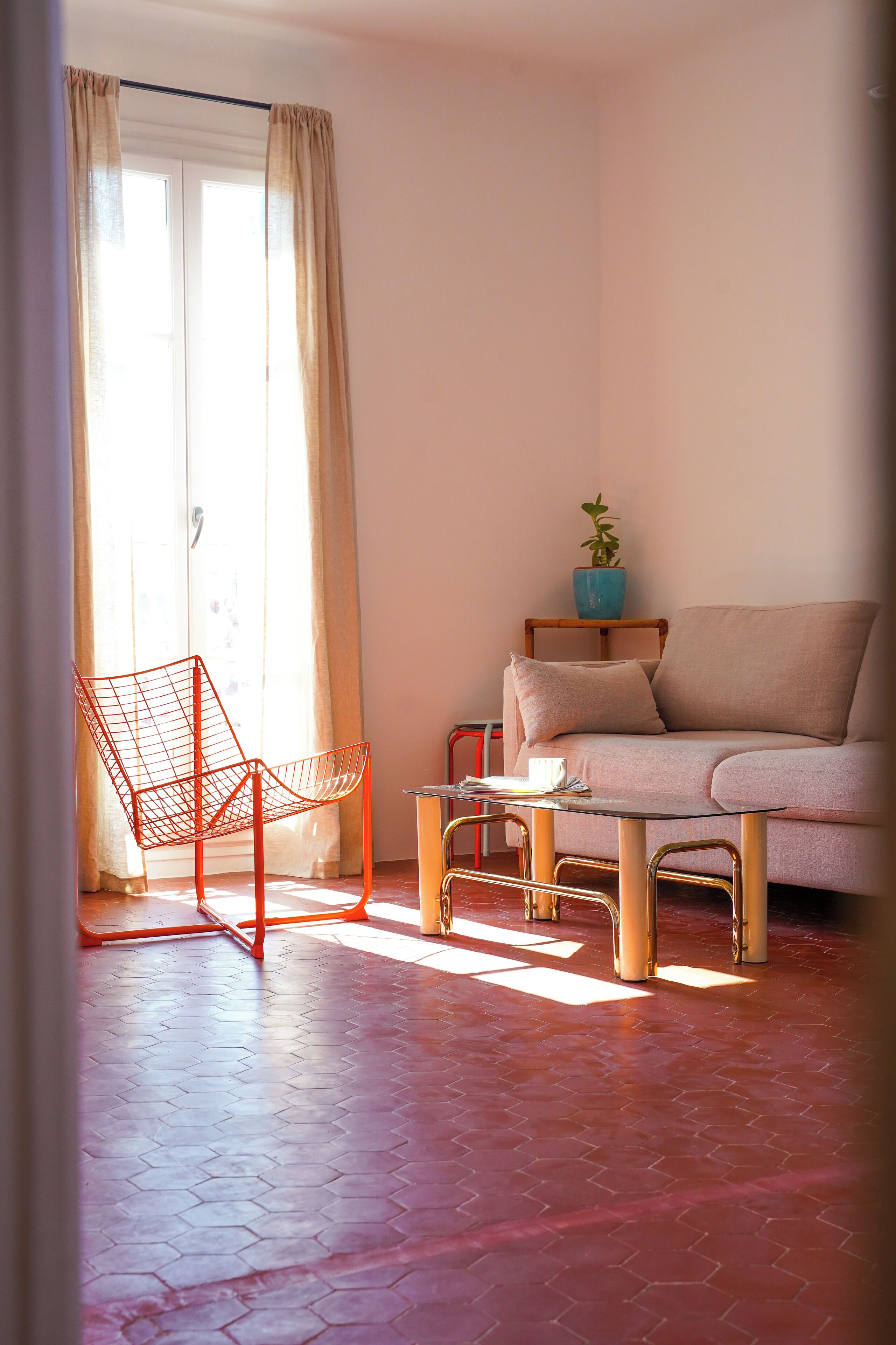 A living room with a sofa, a chair, a table, and a potted plant.