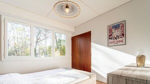 Un dormitorio con una cama, una puerta de madera, una ventana y un cartel en la pared.