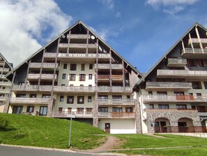 A multi-story hotel with balconies, a stone facade, and a sign indicating 'Accueil'. - Cozy apartment for 4 in Super-Besse with parking (Besse-et-Saint-Anastaise-Super Besse)