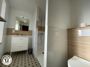 Ein modernes Badezimmer mit Spiegel, Waschbecken und Dusche.