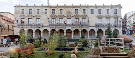 A historic building with a central courtyard, arched walkways, and a flag on the roof.