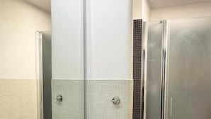 A modern bathroom with two sinks, a toilet, and a glass shower enclosure. - Raffy in Rome (Rome)