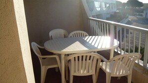 A balcony with a round table and four chairs. - 2-room apartment with terrace and garage in Port Camargue (Port Camargue)
