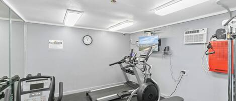 A gym with treadmills, a stationary bike, and a weight bench.