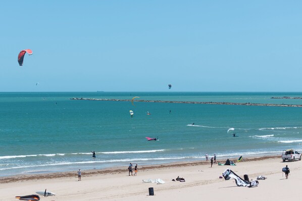 A beach with people, a pier, and a clear sky. - Luxe Corner 3br, Gulf View: Suntide III - Unit 410 (South Padre Island)