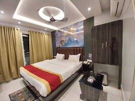 Una habitación de hotel moderna con una cama grande, una mesita de noche, un escritorio y un espejo amplio.