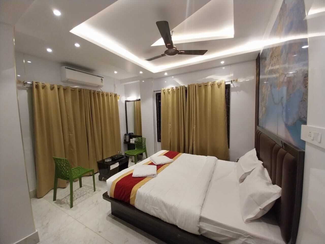 A hotel room with a bed, a desk, a chair, and a ceiling fan.