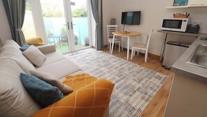 A cozy living area with a sofa, a small table, and a TV. - Blake Lodge (Newquay)