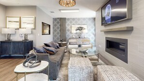 Ein modernes Wohnzimmer mit einer Couch, einem Couchtisch und einem an der Wand montierten Fernseher.