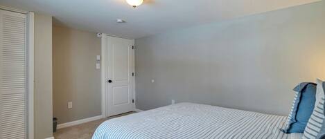 A bedroom with a bed, a closet, and a door.