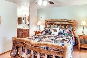 A rustic wooden bed with a quilt, a wooden nightstand with a lamp, and a wooden headboard. - White Mountains Cabin: Near Trails & Lake Access! (Show Low)