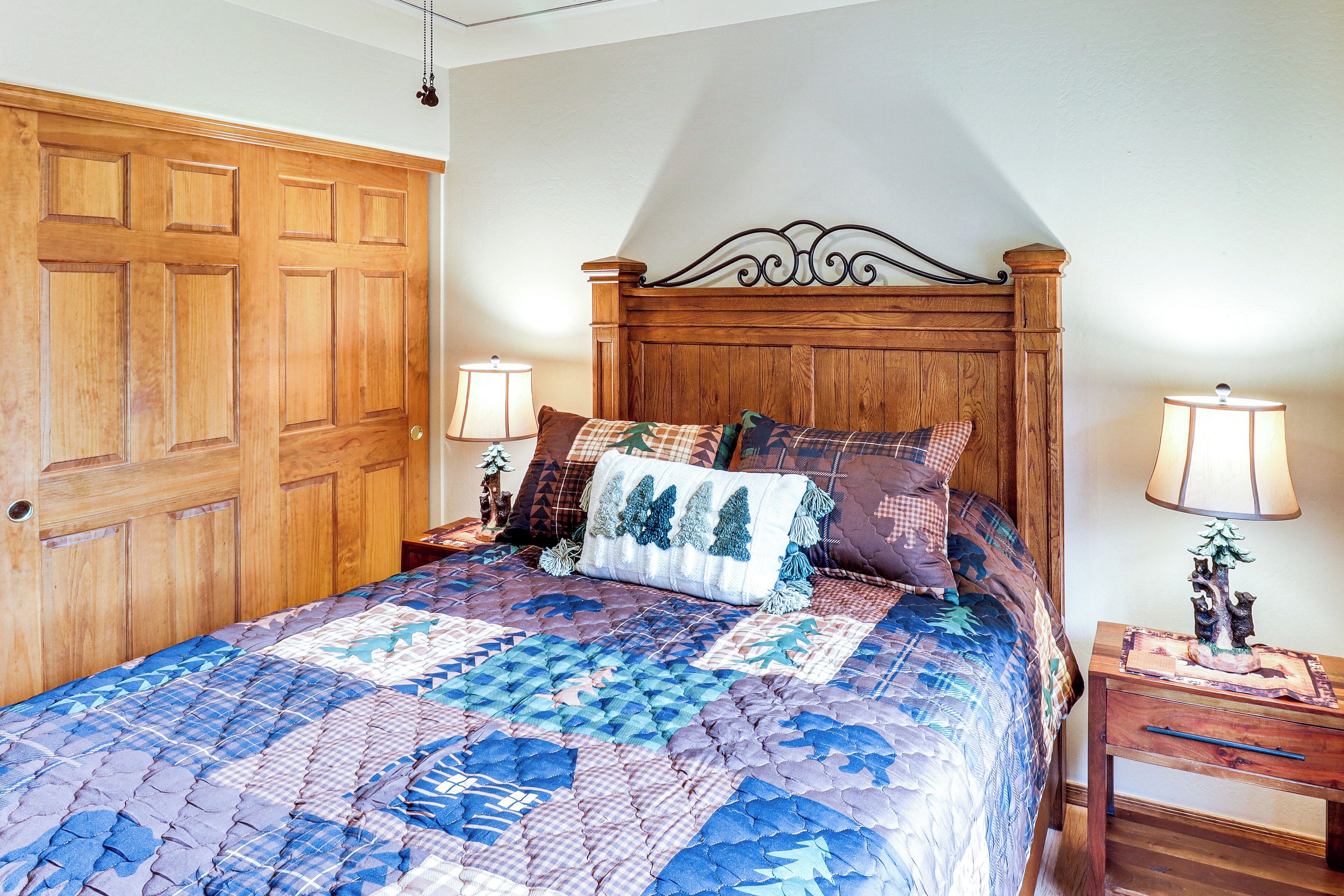 A bedroom with a wooden bed, two bedside tables with lamps, and a wooden wardrobe.