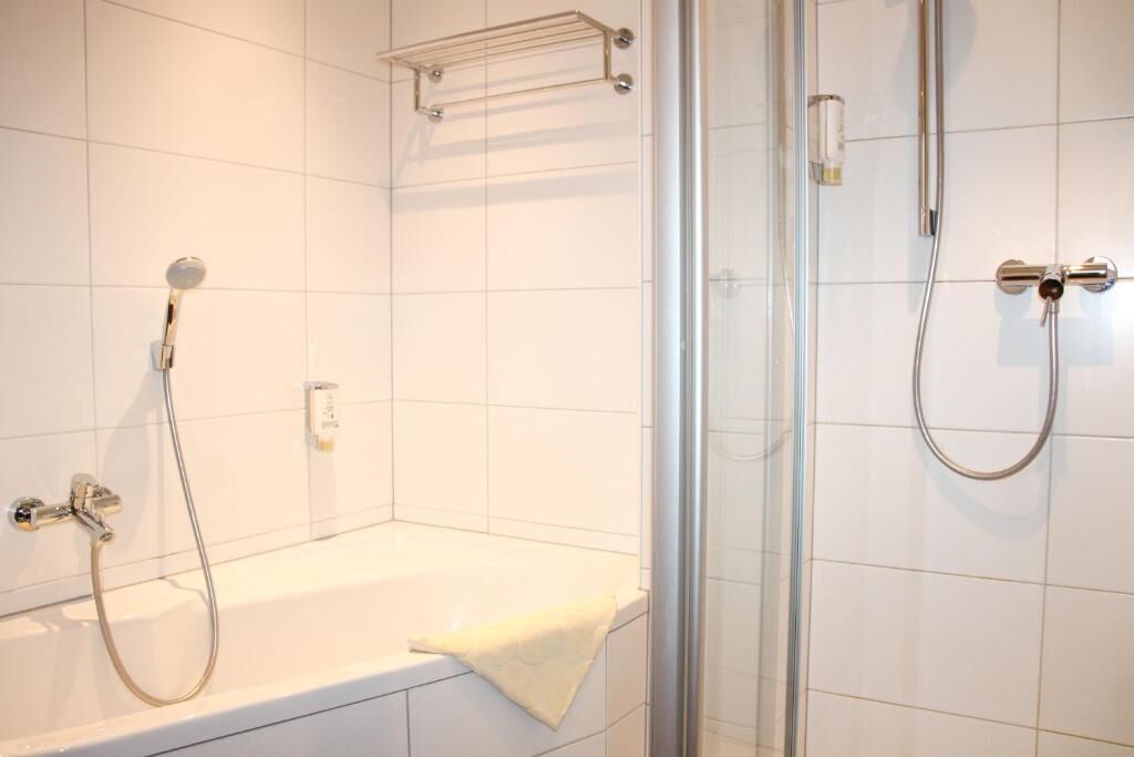 Une salle de bain équipée d’une baignoire, d’un espace douche et d’une paroi de douche en verre.